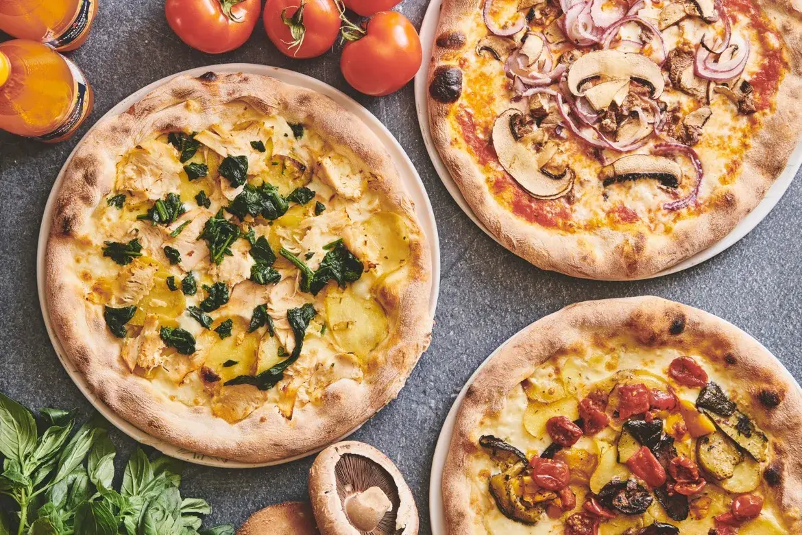 Udvalg af pizzaer med kylling, svampe og grøntsager