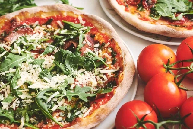 Pizza med rucola, parmesan og friske tomater